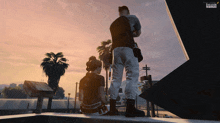 a man and a woman standing on a ledge in a video game with a sunset in the background