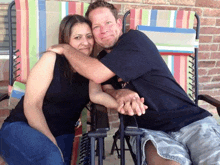 a man and a woman are posing for a picture in a chair