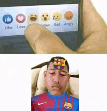 a person is holding a cell phone with a picture of a boy with a fcb logo on his forehead .