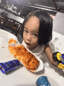 a little girl is eating a piece of bread