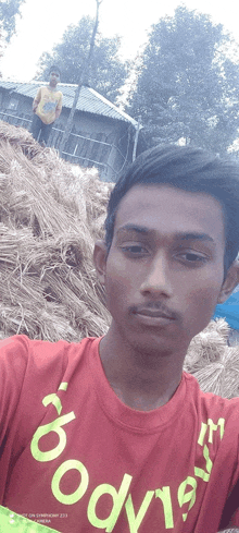 a man in a red shirt with the word body on it takes a selfie