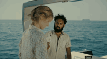 a man and a woman are standing on a boat that has paused on the side