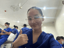 a nurse giving a thumbs up in front of a group of nurses