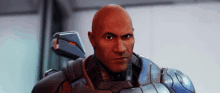 a bald man in a futuristic armor is looking at the camera .