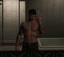 a shirtless man taking a picture of himself in the bathroom