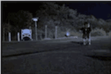 a blurry picture of a person walking down a road at night