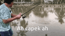 a man is fishing in a lake and the words ah capek ah are visible