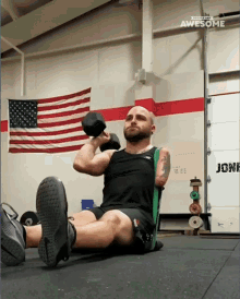 a man with a prosthetic arm is lifting a dumbbell in front of an american flag and a door that says jones