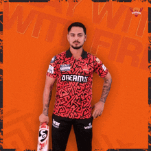 a man holding a cricket bat with the word dreamz on his shirt