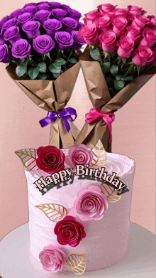 two bouquets of purple and pink roses are next to a pink birthday cake