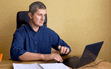 a man sits at a desk using an asus laptop computer