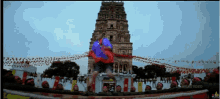 a man in a blue shirt is standing in front of a temple with the word video on the bottom left