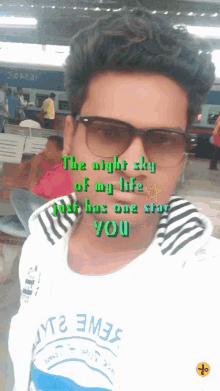 a man wearing sunglasses and a shirt that says ' the night sky of my life just has one star you ' on it