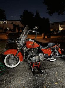 a red harley davidson motorcycle is parked in a dark parking lot