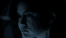 a close up of a woman 's face with a blue light behind her