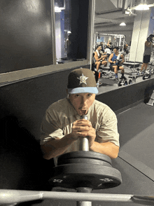 a man wearing a hat with the letter h on it sits in a gym