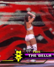 a female wrestler is dancing in front of a screen that says nxt pros the bella 1