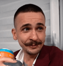 a man with a mustache is drinking from a can of soda