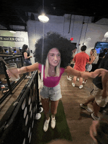 a woman with a big afro is holding a glass of beer