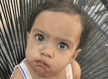 a little girl with curly hair looks at the camera