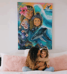 a woman kisses a little girl in front of a painting