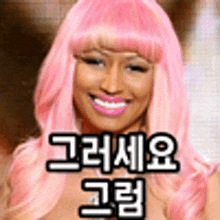 a woman with pink hair is smiling and wearing a pink wig with korean writing on it .