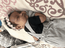 a baby wearing a headband is laying on a blanket