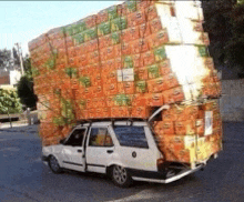 a white car with a large stack of boxes on top