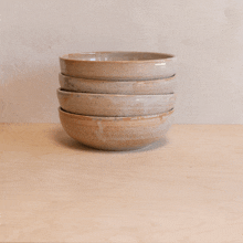 four bowls are stacked on top of each other on a wooden surface