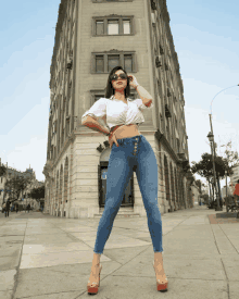 a woman standing in front of a building with a sign that says ' avenida ' on it