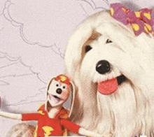 a white dog and a stuffed animal are standing next to each other on a table .