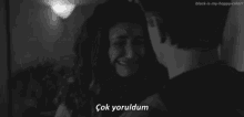 a black and white photo of a man hugging a woman who is crying with a caption that says çok yoruldum