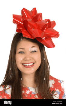 a woman wearing a red bow on her head smiles for the camera