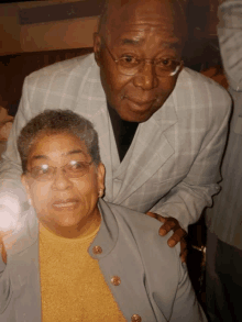 a man and woman posing for a picture with the man 's arm around the woman 's shoulders