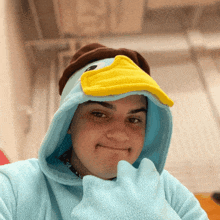 a person wearing a blue hoodie with a duck hat on