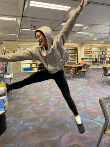 a person is jumping in the air in front of a sign that says exit