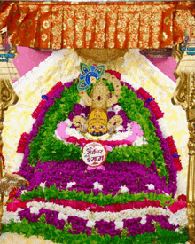 a painting of a statue with flowers and a sign that says ' shree krishna ' on it