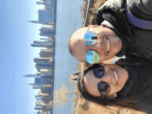 a man and a woman are posing for a picture in front of the new york city skyline