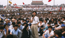 a crowd of people are gathered in front of a building that says ' beijing '