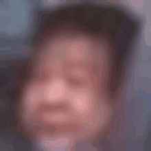 a blurry picture of a person 's face with their eyes closed and their mouth open .