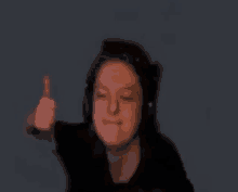 a woman wearing headphones is giving the middle finger .