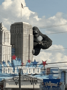 a hollywood wax museum sign with a statue of king kong in the background