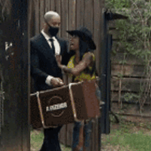 a man in a suit and tie is carrying a briefcase while a woman in a yellow shirt is standing next to him