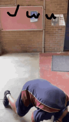 a man is kneeling down in front of a bulletin board with the letter j and w written on it