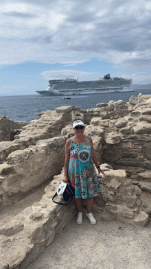 a woman stands in front of a large cruise ship in the ocean