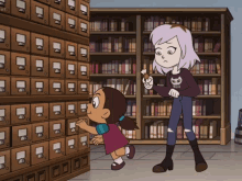 a girl in a purple sweater with a cat on it stands next to a little girl in a library