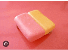 a pink and yellow block of soap on a pink surface