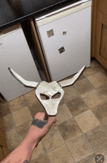 a person with a tattoo on their arm is holding a piece of metal that looks like a bull head