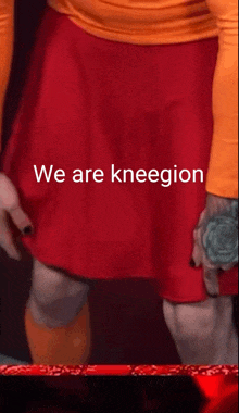 a person wearing a red skirt that says we are kneegin