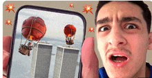 a man is holding a phone with a picture of hot air balloons flying over the twin towers